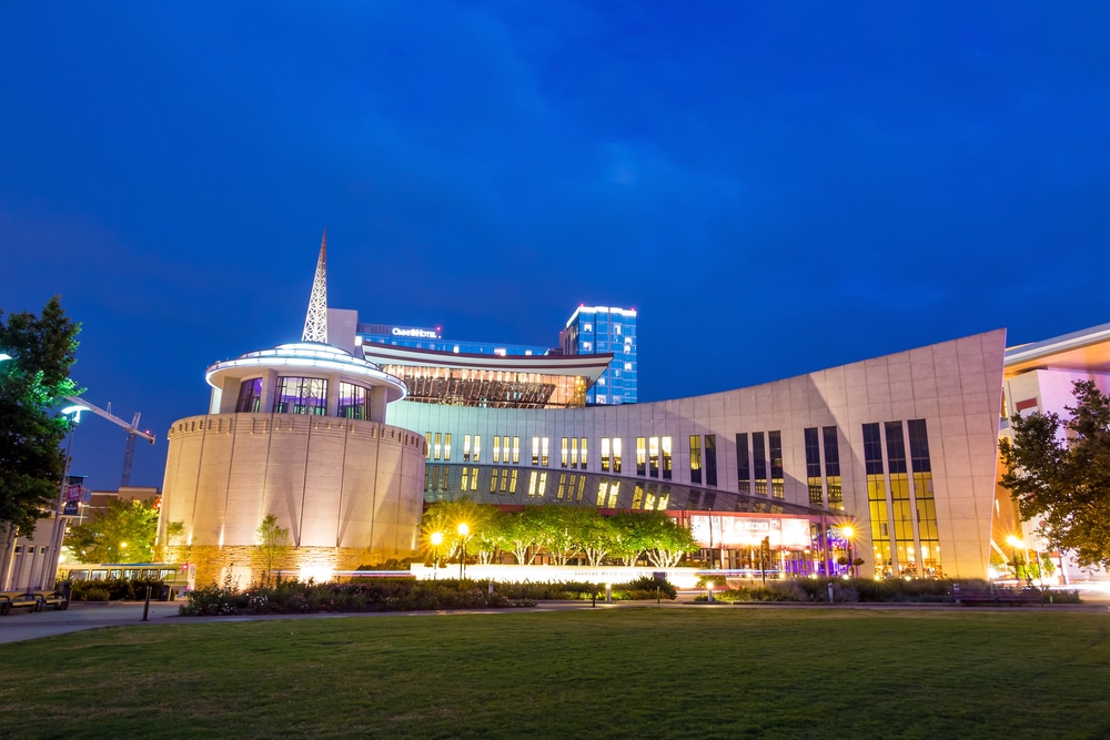 The exterior lit up at night of the Country Music Hall of Fame in Nashville